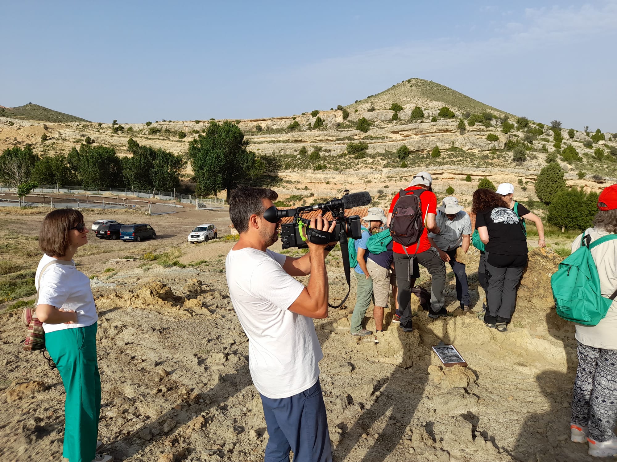 Grupo de estudiantes observando las rocas y siendo grabados para Aragón Noticias.